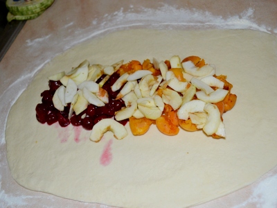 На раскатанный пласт теста выкладываем дорожкой фруктовую начинку